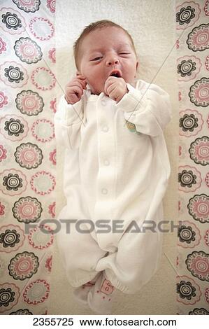 Stock Photography - 6 Day Old Baby Yawns While Lying On A Change Table In Pajamas; Toronto, Ontario, Canada. Fotosearch