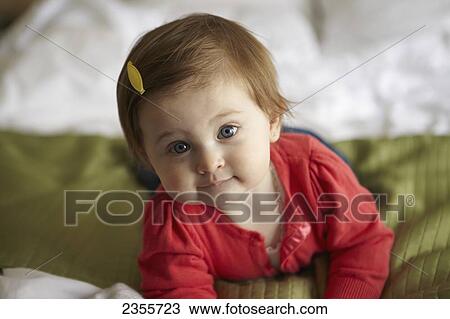 A Baby Girl Poses For A Portrait While Lying On A Bed; Ottawa, Ontario, Canada View Large Photo Image Stock Image - A Baby Girl Poses For A Portrait While Lying On A Bed; Ottawa, Ontario, Canada. Fotosearch