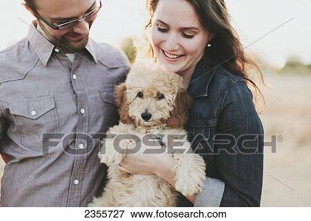A Couple Holding Their Pet Dog; Crescent Beach, British Columbia, Canada View Large Photo Image Stock Photo - A Couple Holding Their Pet Dog; Crescent Beach, British Columbia, Canada. Fotosearch