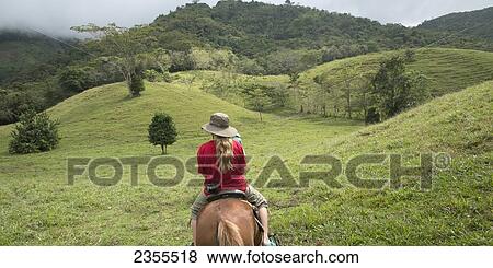 Stock Photo - A Girl Riding Horseback Through The Hills; Zacapa, Guatemala. Fotosearch