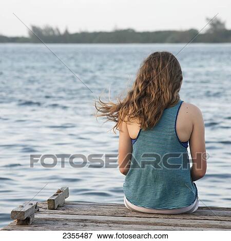 A Girl Sits On The Edge Of A Dock; Utila, Bay Islands, Honduras View Large Photo Image Stock Photo - A Girl Sits On The Edge Of A Dock; Utila, Bay Islands, Honduras. Fotosearch