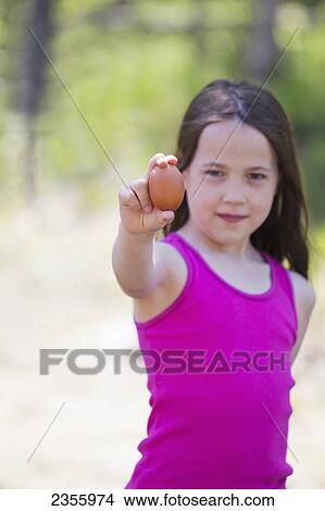 A Girl With A Chicken Egg In Summer; Palmer, Alaska, United States Of America View Large Photo Image Picture - A Girl With A Chicken Egg In Summer; Palmer, Alaska, United States Of America. Fotosearch