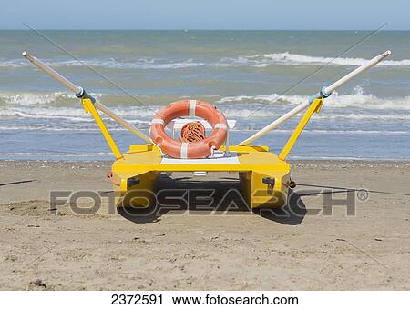 A Lifeboat Sitting On The Beach At The Water's Edge; Rimini, Emilia-Romagna, Italy View Large Photo Image Stock Image - A Lifeboat Sitting On The Beach At The Water's Edge; Rimini, Emilia-Romagna, Italy. Fotosearch