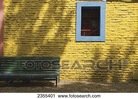A Painted Yellow Brick Wall With A Blue Trimmed Window And A Green Bench; Buenos Aires, Argentina View Large Photo Image Stock Image - A Painted Yellow Brick Wall With A Blue Trimmed Window And A Green Bench; Buenos Aires, Argentina. Fotosearch