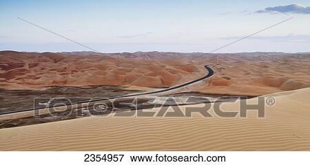 A Road Through The Desert Landscape; Liwa Oasis, Abu Dhabi, United Arab Emirates View Large Photo Image Stock Photo - A Road Through The Desert Landscape; Liwa Oasis, Abu Dhabi, United Arab Emirates. Fotosearch
