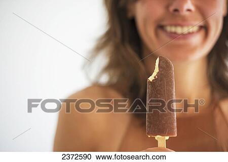 A Woman Eating A Frozen Ice Cream Treat; Locarno, Ticino, Switzerland View Large Photo Image Stock Image - A Woman Eating A Frozen Ice Cream Treat; Locarno, Ticino, Switzerland. Fotosearch