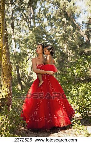 A woman in a formal red gown holding a young girl with a red tutu; Honolulu, Hawaii, United States of America View Large Photo Image Stock Photograph - A woman in a formal red gown holding a young girl with a red tutu; Honolulu, Hawaii, United States of America. Fotosearch