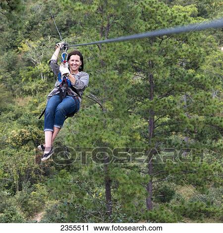 Stock Image - A Woman On A Zip-Line; Copan, Honduras. Fotosearch