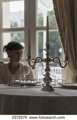 A Woman Sits By A Window At A Formal Table Set For A Meal; Rimini, Emilia-Romagna, Italy View Large Photo Image Stock Photo - A Woman Sits By A Window At A Formal Table Set For A Meal; Rimini, Emilia-Romagna, Italy. Fotosearch