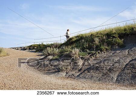 Stock Photo - A Woman Walks On A Path In The Badlands; Drumheller, Alberta, Canada. Fotosearch