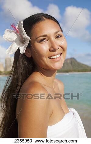 A Young Woman Poses On A Beach With A Hibiscus Flower In Her Hair; Waikiki, Oahu, Hawaii, United States Of America View Large Photo Image Stock Image - A Young Woman Poses On A Beach With A Hibiscus Flower In Her Hair; Waikiki, Oahu, Hawaii, United States Of America. Fotosearch