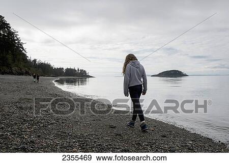 A Young Woman Walks On A Rocky Beach In Deception Pass State Park; Oak Harbor, Washington, United States Of America View Large Photo Image Stock Photo - A Young Woman Walks On A Rocky Beach In Deception Pass State Park; Oak Harbor, Washington, United States Of America. Fotosearch