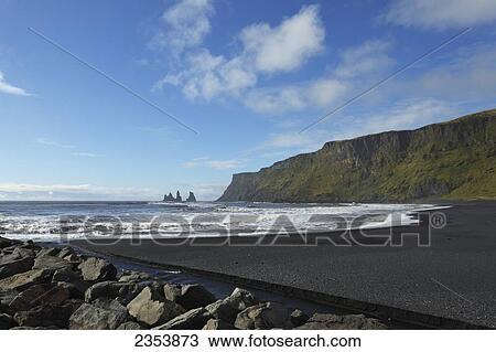 Stock Image - Black Lava Beach With Basalt Stacks Of Reynisdrangar In The Background; Vik, Vestur-Skaftafellssysla, Iceland. Fotosearch