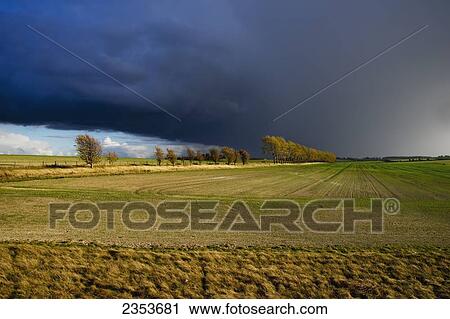 Stock Image - Farmland Under A Dark Cloudy Sky; Hertfordshire, England. Fotosearch
