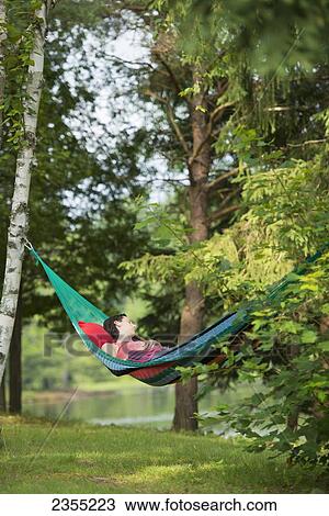 Stock Image - Girl Sleeping In Hammock With Headphones; Ontario, Canada. Fotosearch