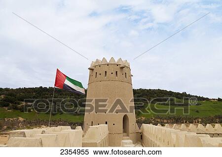 Stock Photography - Mezaira Fort And Uae Flag; Liwa Oasis, Abu Dhabi, United Arab Emirates. Fotosearch