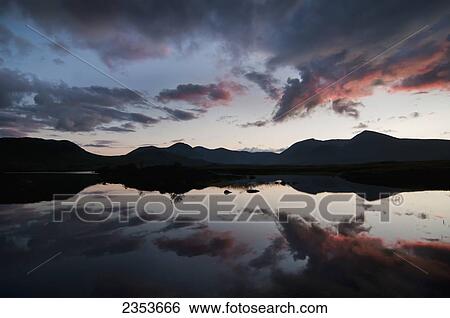 Stock Photograph - Mirror Image Of Silhouetted Mountains And Clouds At Sunset In A Lake; Rannoch Moor, Scotland. Fotosearch