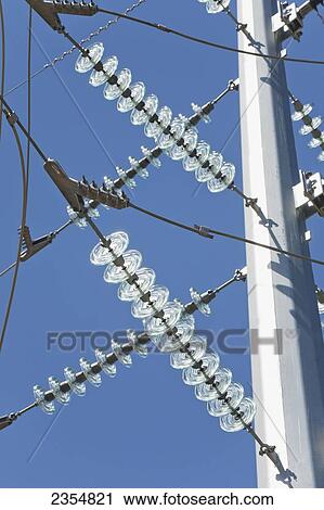Stock Image - Shiny High Voltage Glass Electrical Insulators On A Metal Electrical Pole With Deep Blue Sky; Beiseker, Alberta, Canada. Fotosearch
