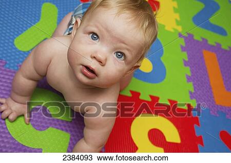 A baby boy crawls on a colourful play mat; Alberta, Canada View Large Photo Image Stock Image - A baby boy crawls on a colourful play mat; Alberta, Canada. Fotosearch