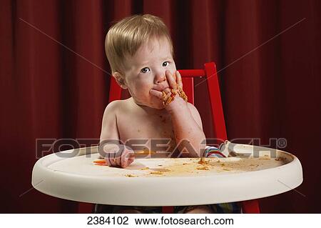 A baby boy sits in a high chair eating a messy meal of spaghetti; Alberta, Canada View Large Photo Image Stock Image - A baby boy sits in a high chair eating a messy meal of spaghetti; Alberta, Canada. Fotosearch
