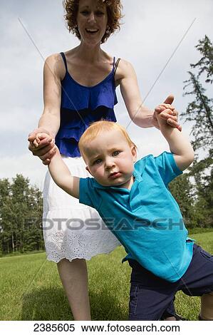 A baby with red hair learning to walk and holding onto his mother's hands; Stony Plain, Alberta, Canada View Large Photo Image Stock Photography - A baby with red hair learning to walk and holding onto his mother's hands; Stony Plain, Alberta, Canada. Fotosearch