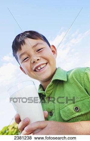 A boy holding a glass of milk with a milk moustache; Honolulu, Oahu, Hawaii, United States of America View Large Photo Image Stock Photo - A boy holding a glass of milk with a milk moustache; Honolulu, Oahu, Hawaii, United States of America. Fotosearch