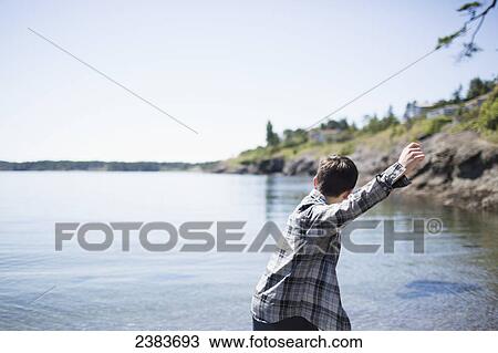 A boy throws rocks into the water; Victoria, British Columbia, Canada View Large Photo Image Stock Image - A boy throws rocks into the water; Victoria, British Columbia, Canada. Fotosearch