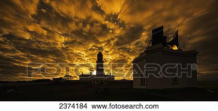 Picture - A dramatic golden sky illuminated at sunset with silhouette of buildings; Whitburn, Tyne and Wear, England. Fotosearch