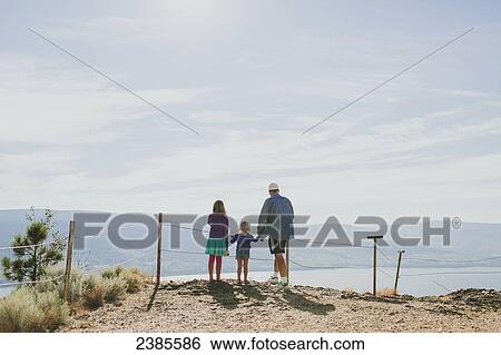 A family stands together overlooking a view of Lake Okanagan; Peachland, British Columbia, Canada View Large Photo Image Stock Photograph - A family stands together overlooking a view of Lake Okanagan; Peachland, British Columbia, Canada. Fotosearch