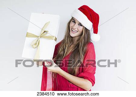 A girl dressed in a red shirt and santa hat holds a wrapped gift; Hawaii, United States of America View Large Photo Image Stock Image - A girl dressed in a red shirt and santa hat holds a wrapped gift; Hawaii, United States of America. Fotosearch