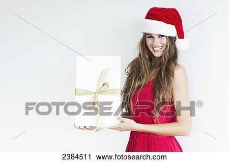 A girl dressed in a red shirt and santa hat holds a wrapped gift; Hawaii, United States of America View Large Photo Image Stock Image - A girl dressed in a red shirt and santa hat holds a wrapped gift; Hawaii, United States of America. Fotosearch