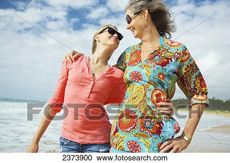 Stock Image - A mother and daughter together on the beach; Kauai, Hawaii, United States of America. Fotosearch