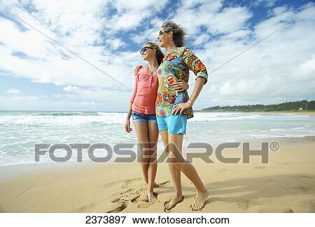 Stock Photo - A mother and daughter together on the beach; Kauai, Hawaii, United States of America. Fotosearch