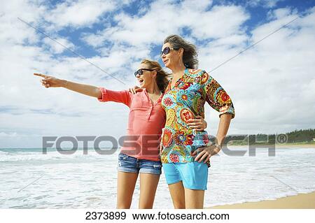 Stock Photo - A mother and daughter together on the beach; Kauai, Hawaii, United States of America. Fotosearch