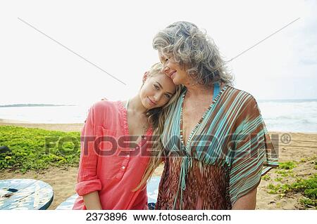 Stock Photograph - A mother and daughter together on the beach; Kauai, Hawaii, United States of America. Fotosearch