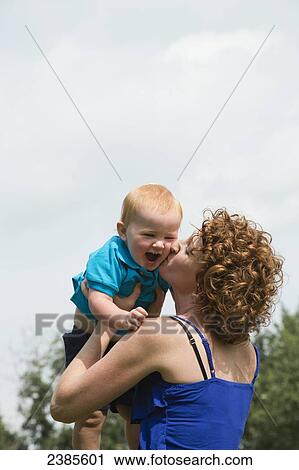 A mother kisses and plays with her young son; Stony Plain, Alberta, Canada View Large Photo Image Stock Image - A mother kisses and plays with her young son; Stony Plain, Alberta, Canada. Fotosearch