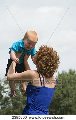 Stock Image - A mother plays with her young son; Stony Plain, Alberta, Canada. Fotosearch