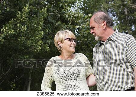 A senior couple talking in a park; Stony Plain, Alberta, Canada View Large Photo Image Stock Photography - A senior couple talking in a park; Stony Plain, Alberta, Canada. Fotosearch