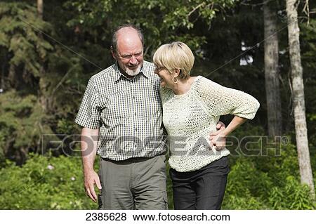 Stock Photo - A senior couple walking and talking together in a park; Stony Plain, Alberta, Canada. Fotosearch