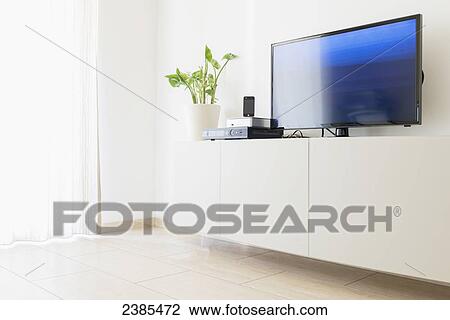 A television sits on a white stand with a plant; Locarno, Ticino, Switzerland View Large Photo Image Stock Image - A television sits on a white stand with a plant; Locarno, Ticino, Switzerland. Fotosearch
