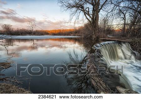A waterfall flows strong as it funnels the melting snow and ice; Wisconsin, United States of America View Large Photo Image Stock Image - A waterfall flows strong as it funnels the melting snow and ice; Wisconsin, United States of America. Fotosearch