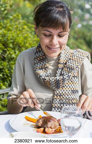 A woman eating a meal; Locarno, Ticino, Switzerland View Large Photo Image Stock Image - A woman eating a meal; Locarno, Ticino, Switzerland. Fotosearch