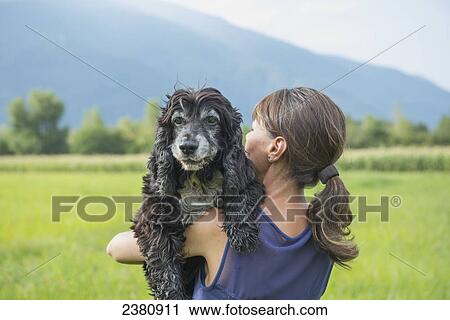 Stock Image - A woman holding her dog; Locarno, Ticino, Switzerland. Fotosearch