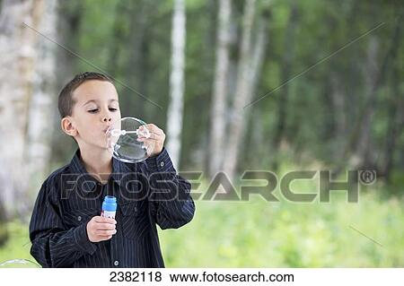A young boy blows bubbles in the summertime; Palmer, Alaska, United States of America View Large Photo Image Stock Photo - A young boy blows bubbles in the summertime; Palmer, Alaska, United States of America. Fotosearch