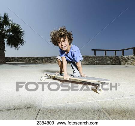 Stock Photo - A young boy on a skateboard; Tarifa, Cadiz, Andalusia, Spain. Fotosearch