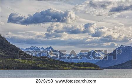 Afternoon clouds over the Yukon Coast Mountains and Bennett Lake; Yukon, Canada View Large Photo Image Stock Image - Afternoon clouds over the Yukon Coast Mountains and Bennett Lake; Yukon, Canada. Fotosearch