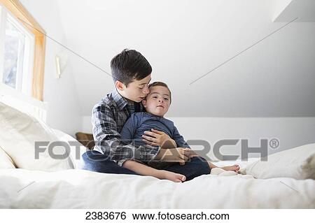 An older brother holds his young brother with down syndrome; Victoria, British Columbia, Canada View Large Photo Image Stock Photograph - An older brother holds his young brother with down syndrome; Victoria, British Columbia, Canada. Fotosearch