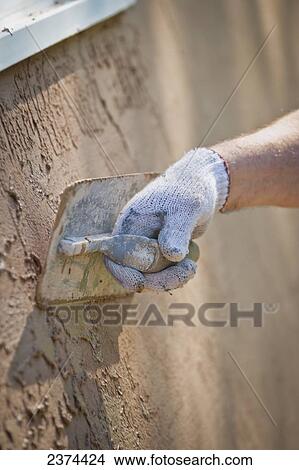 Applying stucco to a building; St. Albert, Alberta, Canada View Large Photo Image Picture - Applying stucco to a building; St. Albert, Alberta, Canada. Fotosearch