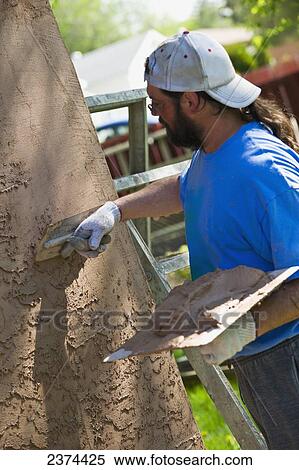 Applying stucco to a building; St. Albert, Alberta, Canada View Large Photo Image Stock Photography - Applying stucco to a building; St. Albert, Alberta, Canada. Fotosearch