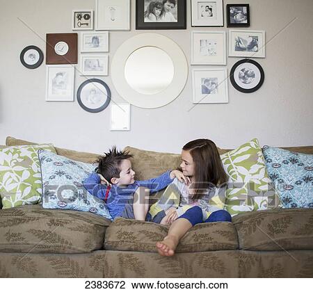 Brother and sister sitting on a couch at home; Victoria, British Columbia, Canada View Large Photo Image Stock Image - Brother and sister sitting on a couch at home; Victoria, British Columbia, Canada. Fotosearch